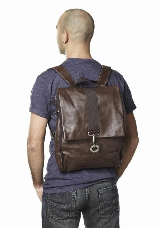 Man wearing a brown leather backpack on a white background